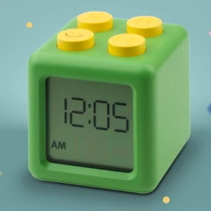 Green LEGO-style block alarm clock with yellow top studs showing 12:05 AM on the display.